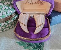 Pair of carved mother of pearl earrings in purple velvet box