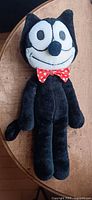 Full view of Felix the Cat plush laying flat