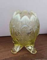 Front view of Northwood vaseline glass footed rose bowl showing pattern and feet