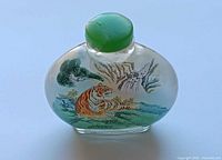 Front view showing resting tiger artwork and green chipped lid