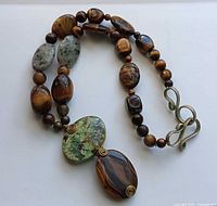 Full view of necklace showing bead pattern, pendant stones, and clasp