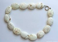 Entire necklace laid flat showing stone pattern and clasp