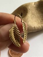 Close-up of both earrings showing leaf design and ear wires