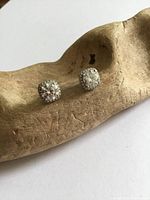 front view of both stud earrings showing halo setting and central stones