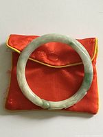 Full view of jade bangle on red pouch