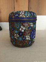 Front view of cloisonné container showing floral motif and lid in place