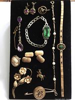 All jewelry pieces arranged on black board for complete lot overview