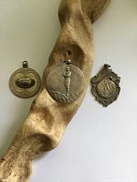 Three sterling silver sports medallions on wood prop
