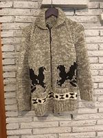 Front view of wool Cowichan sweater on hanger