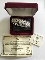 Bracelet inside open presentation box with certificate and booklet