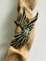 Full view of brooch showing bird shape and color detailing