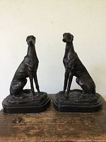Both bronze greyhound sculptures on bases, frontal view