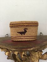 Front view showing basket side with bird motif and red bands