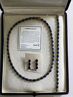 Set in presentation box showing necklace, bracelet, earrings, info card