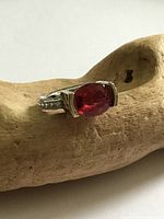 Ring front view showing red faceted stone and silver setting
