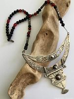 Full necklace draped on wood showing pendant and bead strand