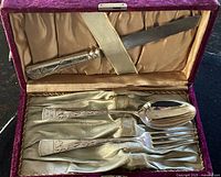 open case showing knife, spoon, fork with engraved handles