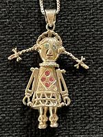front view of articulated sterling doll pendant with chain