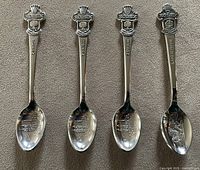 Front view of four Rolex souvenir spoons, three Zurich one Lucerne