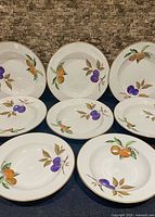 Front view of eight Royal Worcester Evesham soup bowls showing fruit design and gold rim