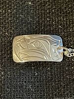 Front view of engraved eagle pendant on chain