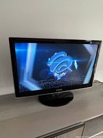 Front view of Samsung 27" TV powered on displaying image