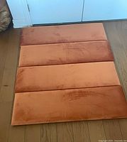 Four burnt orange velvet headboard panels laid out together