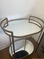 Full view of bar cart showing top mirrored shelf and gold frame