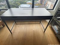 Front view of grey desk showing drawers and metal legs