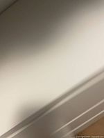 Close view of white dresser surface and drawer edge