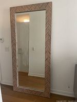 Front view of full floor mirror leaning against wall