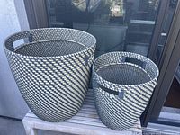 Both black-beige woven resin wicker planters side by side