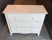 Front view showing three drawers and knobs