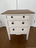 Front view showing three drawers, hardware, paint finish