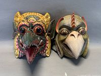 Front view of both carved masks side by side