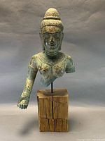 Full front view of Buddha torso on wood base