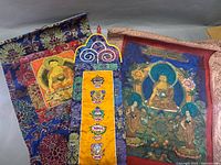 Front view of three brocade hangings showing designs and colours