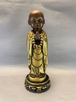 Front view of praying Buddha statue showing overall design and finish