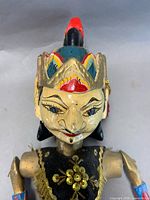 Front view of cream-faced female puppet showing facial detail and costume