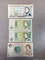 Fronts of four banknotes (£5, 2 × £1, £10)