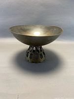 Side view of metal pedestal bowl showing openwork base and profile
