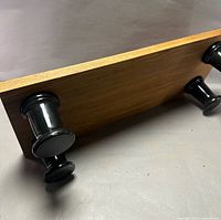 Underside of oak board showing two black turned legs attached