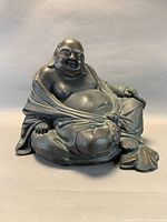 Front left view of metal laughing Buddha statue