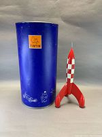 Rocket and blue container side by side