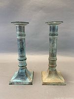 Two verdigris patina candlesticks front view