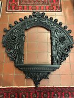 Full view of ornate arched wood frame on floor