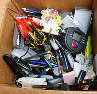 Top view of box showing pens, markers, glue gun, timer, snowman clip, sticky notes