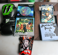 Top view showing boxing gloves, two boxed puzzles, bagged Star Wars puzzle, PC game case, framed puzzle