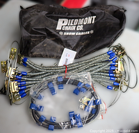 Full set of snow cables, adjusters and carry bag visible