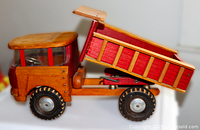 Side view of Dejou wooden dump truck with dump bed raised